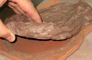peeling clay off a bisque slab